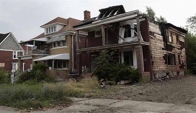 A vacant blighted home is seen next to a well-kept occupied home on West Grand Boulevard in Detroit, Michigan July 23, 2013. REUTERS/ Rebecca Cook